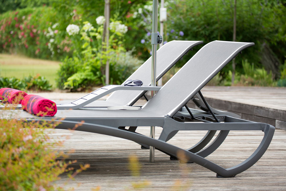 une double chaise longue en bord de piscineinvite à la détente à deux.