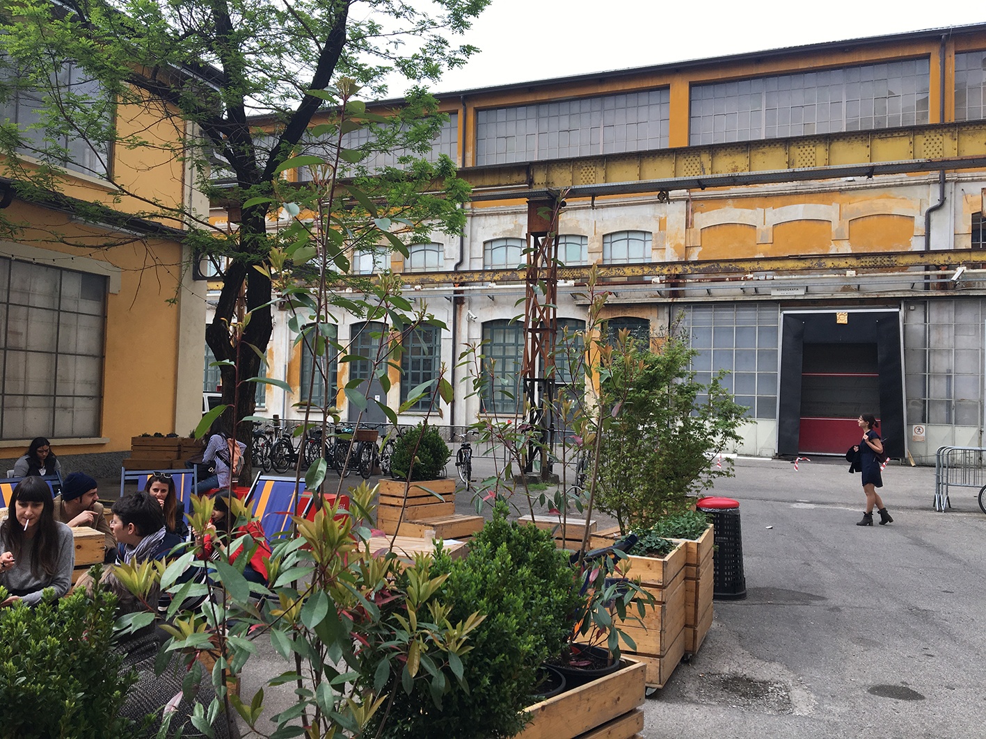 Dans une cour d'anciens batimants industriels, une terrasse de bistrot improvisée reçoit le svisiteurs de la Design Week de Milan