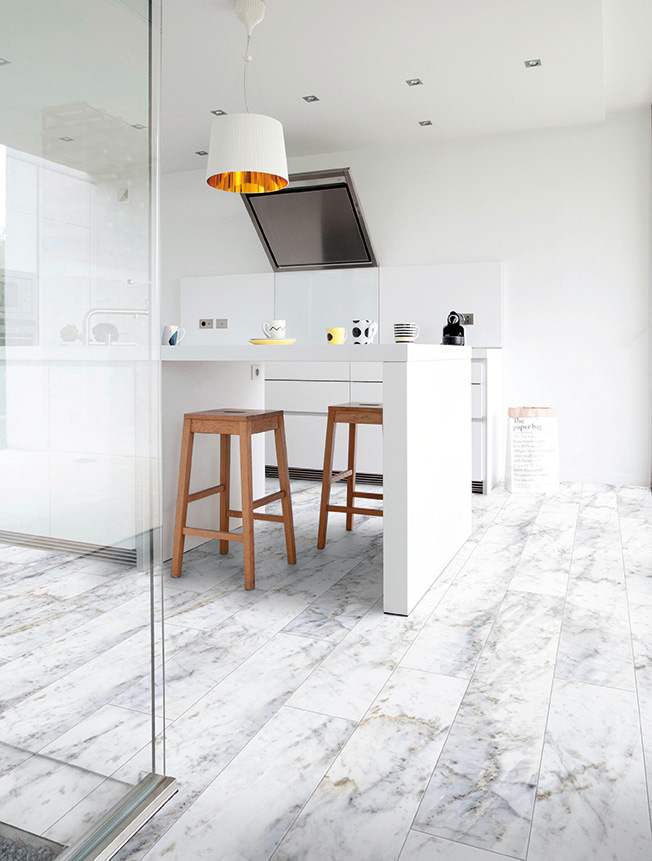 une jolie cuisine contemporaine avec un bar blanc et des mange debout en bois clair. Le sol est décoré de sol Gerflor imitation marbre blanc