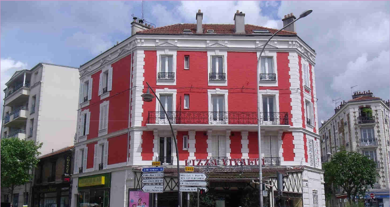 Façade d'immeuble ancien en région parisienne avec une couleur rouge vif