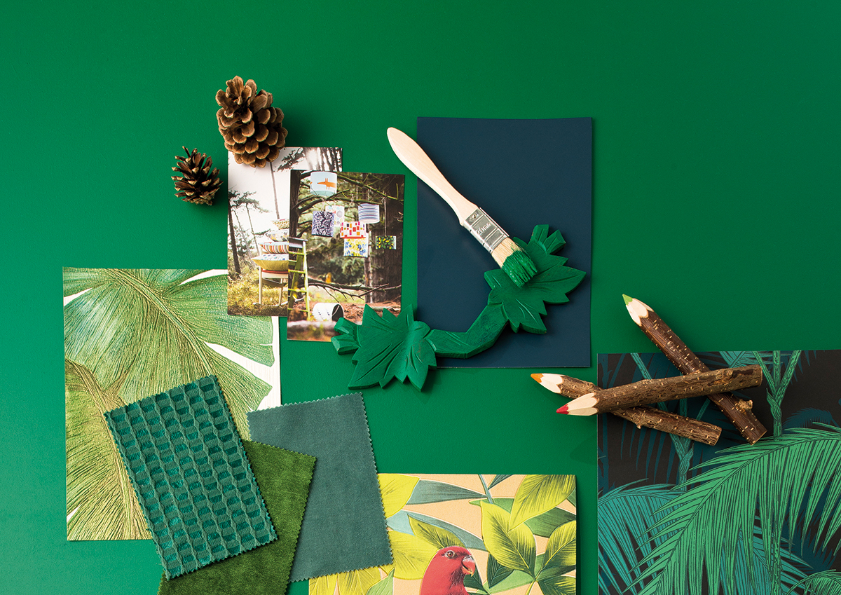 sur un fond Green Forest, vert forêt, un pêle mêle de pinceu, tissus et échantillons de papier peint sur lethème de la forêt et de la jungle