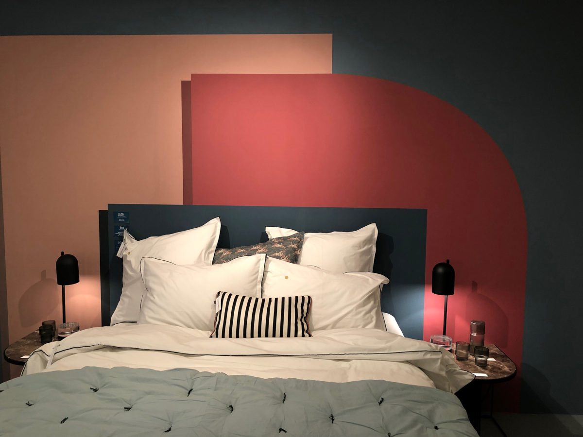 une chambre à coucher avec une tête de lit composée de 3 formes géométriques vert canard et rose saumon