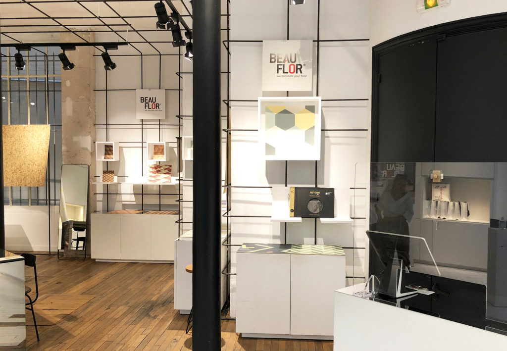 des échantillons de sol vinyle Beauflor sont présentés dans des coffrets blancs accrochés au mur de la galerie