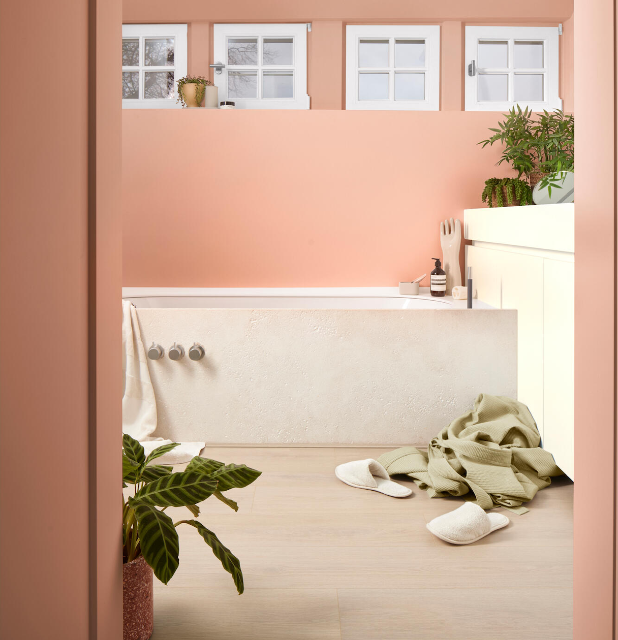 Un sol stratifié qui résiste à l'eau illumine cette salle de bain aux murs pêche.